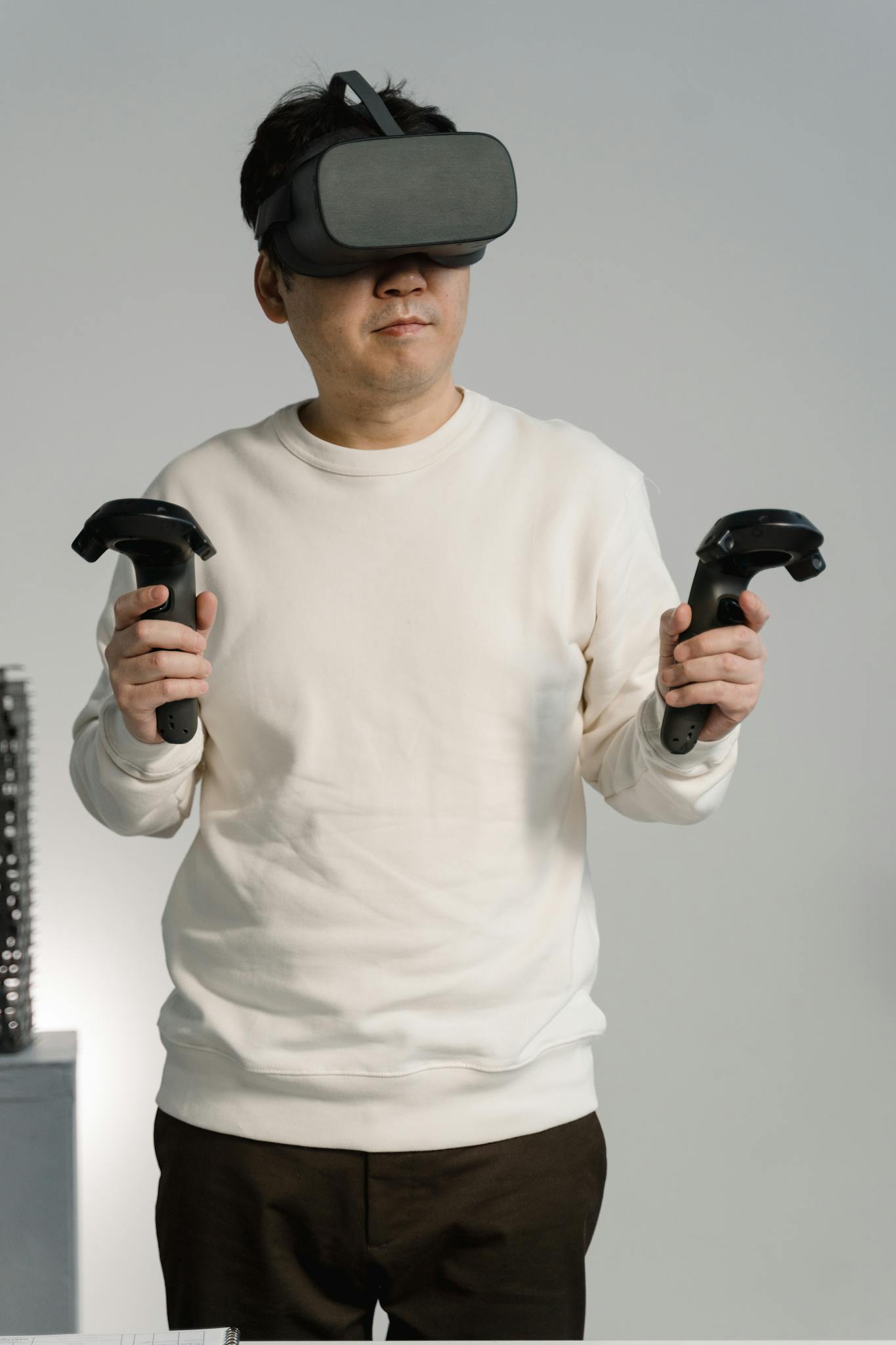 Adult man wearing VR headset and controllers, immersed in a virtual reality environment.
